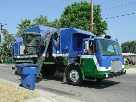 Workers loading assorted commercial waste into a van in a business park clearance