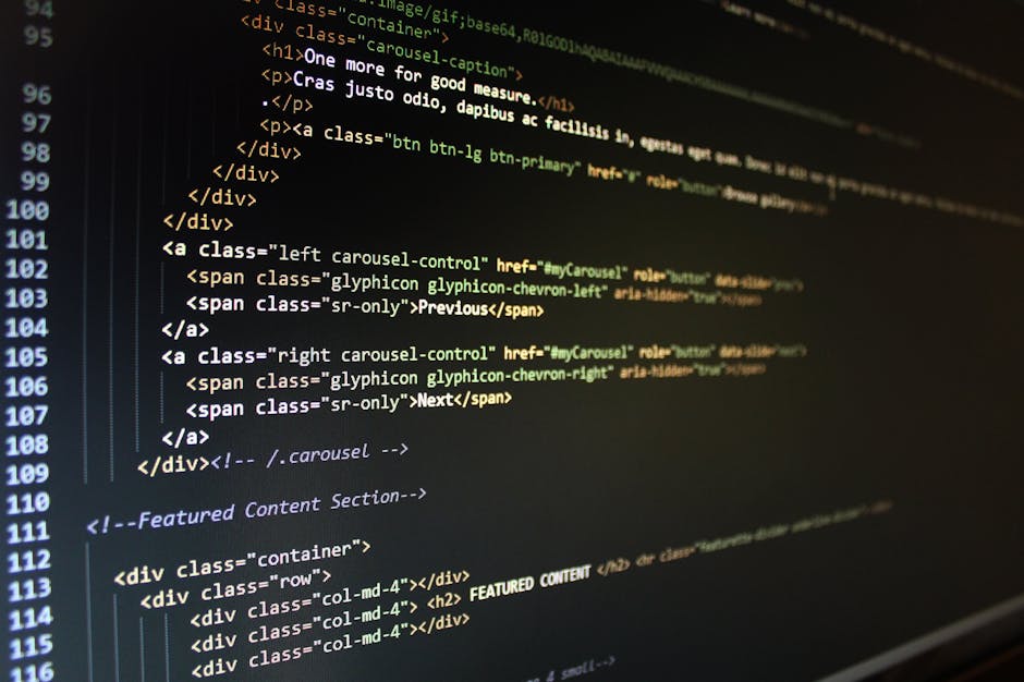 A person's hand, wearing a wristwatch, is typing on a silver laptop keyboard placed on a wooden surface with visible grain and texture. The laptop screen displays lines of code or text in a dark backg
